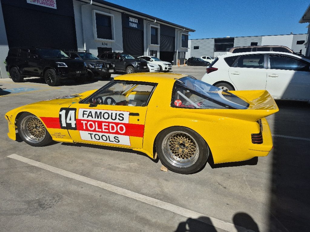 Finished yellow RX-7 race car in Famous Toledo Tools livery after respray at MRP Automotive